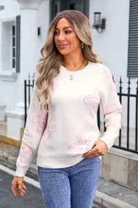 Detail of white long-sleeved crewneck sweater with pink floral patterns for women