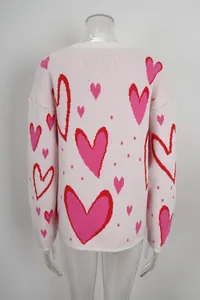 Detail showing the back of a loose pink knitted sweater featuring red and pink heart patterns