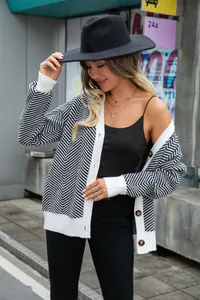 Detail of women's black and white chevron knit cardigan with buttons and v-neck style.
