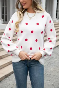 Macro detail of high-quality white knitted pullover sweater with vibrant red polka dots