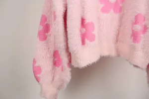 Primer plano de cárdigan de punto rosa con estampados florales y textura suave