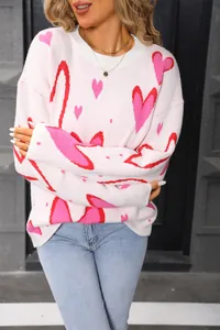 Close-up of pink oversized sweater with vibrant red heart pattern and a classic round neck