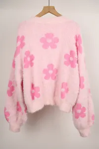 Vista detallada de un suéter de punto rosa suave con grandes patrones florales de estilo mohair