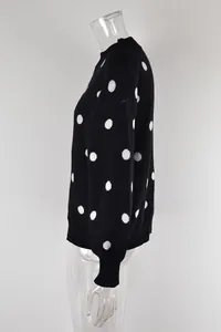 Side profile of a black knit pullover sweater with white polka dots on mannequin