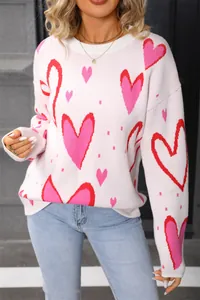 Detail view of pink heart pattern knit sweater with crew neck for women