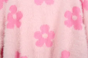 Primer plano del suave tejido de punto rosa con vibrantes detalles florales fucsia