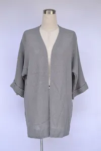 Detail eines grauen Strickkardigans mit lockerer Passform und strukturierter Strickart