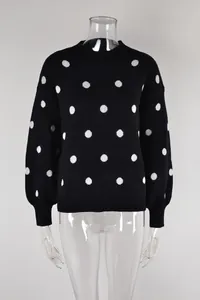 Detailed view of a black knitted pullover sweater featuring a white polka dot pattern.