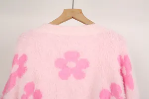 Detalle de cerca del jersey de punto rosa suave con textura de mohair y patrón floral