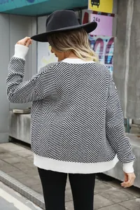 Back view of a woman wearing a black and white chevron pattern knit cardigan sweater