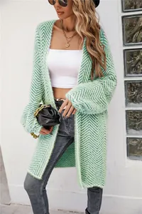 Model wearing mint green chevron knit cardigan with white crop top and grey jeans