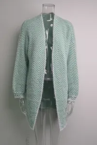 Detail of mint green fuzzy knit cardigan with white chevron pattern texture.