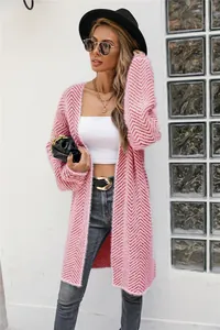 Detail view of a longline pink chevron knit cardigan worn with street style accessories.