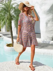 Vestido de playa de punto colorido con cuello en V para mujer junto a una piscina de lujo.