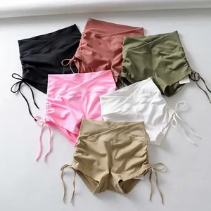 Vista de detalle de pantalones cortos de yoga de talle alto con cintura cruzada y cordones