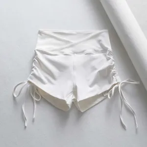 Primer plano de pantalones cortos de yoga blancos con lados fruncidos y cordones.