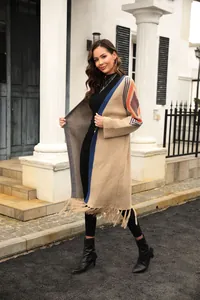 Full-length view of long knitted cardigan with colorful sleeve patterns and fringe.