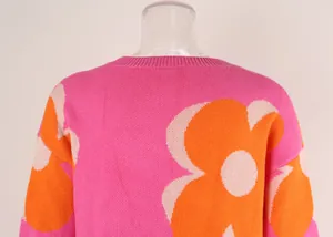 Detailed close-up showing the vibrant orange floral pattern on a pink knit sweater