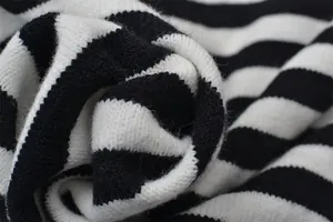 Détail en gros plan de la texture en maille rayée noire et blanche pour ce pull doux