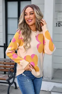 Close-up of women's crewneck knit sweater featuring large pink and yellow floral prints.