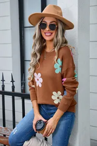 Detail shot of brown crew neck knit sweater with colorful flower patterns