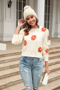 Detailed look of a cream floral knit sweater featuring orange daisy patterns and a crew neck.