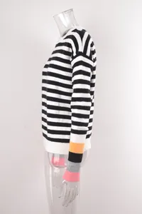 Pull en maille à rayures noires et blanches avec des détails de manches colorées.