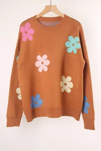 Close-up of vibrant floral jacquard patterns on a brown knit crewneck sweater.