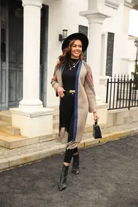 Elegant long knit cardigan with colorful stripes and fringe detail on the street.