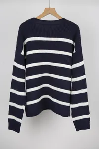 Close-up of a retro oversized blue and white striped knit sweater on a wooden hanger.