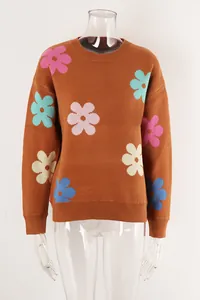 Close-up of brown knit sweater featuring colorful flower patterns and round neck.