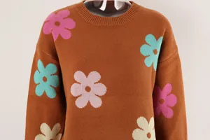Detail shot of a brown knitted sweater featuring vibrant multi-color flower patterns