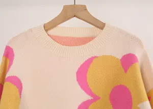 Close-up of women's crew neck knitted sweater with large yellow and pink floral pattern