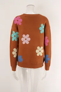 Detailed view of brown knit sweater with vibrant floral patterns on a clear mannequin.