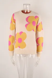 Detail view of a beige knit sweater with pink and yellow floral prints on a mannequin.