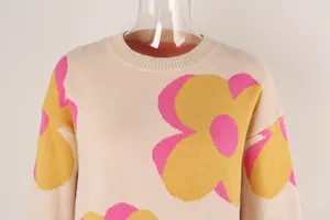 Close-up detail of women's knit sweater with large pink and yellow floral print
