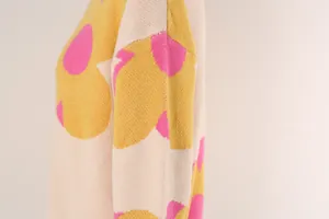 Detailed view of women's knitted sweater featuring large pink and yellow floral patterns