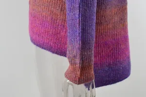Close-up of vibrant gradient tie-dye knit texture on a cozy women's sweater sleeve.