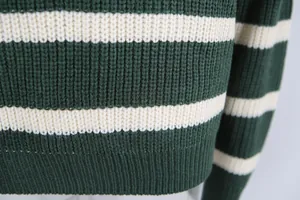 Close-up detail of a retro green and cream striped knit sweater with soft texture