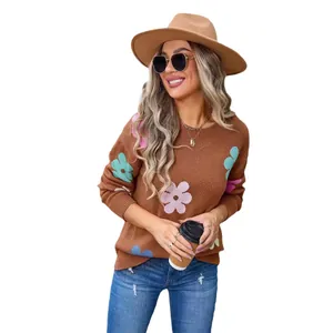 Stylish brown knit sweater with colorful floral patterns worn by a model in a hat