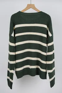 Close-up of a vintage green and white striped oversized knit sweater on a wooden hanger