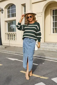 Outdoor street view of a woman wearing a green and white striped oversized knit sweater