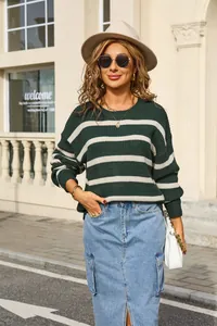 Outdoor lifestyle shot showing a green and white striped oversized knit sweater.