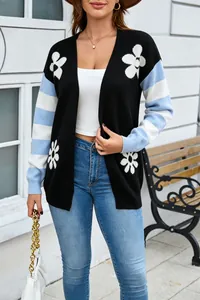 Primo piano di un cardigan in maglia con motivi floreali e maniche a righe su una modella.
