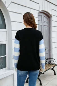 Vista posteriore dettagliata di un maglione nero in maglia con maniche a righe blu e bianche.
