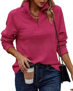 Detailopname van een roze geribbelde damessweatshirt met een halve rits en kraag.
