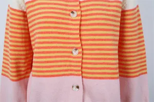 Gros plan d'un cardigan rayé en maille aux couleurs orange, jaune et rose vif.