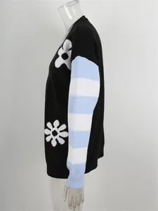 Dettaglio laterale di cardigan oversize in maglia con maniche a righe e fiori