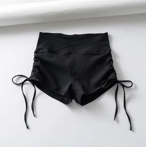 Detalle de pantalones cortos de yoga negros de talle alto con cordones y frunces
