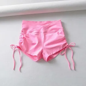 Detalle de pantalones cortos de yoga rosa con cintura cruzada y cordones laterales